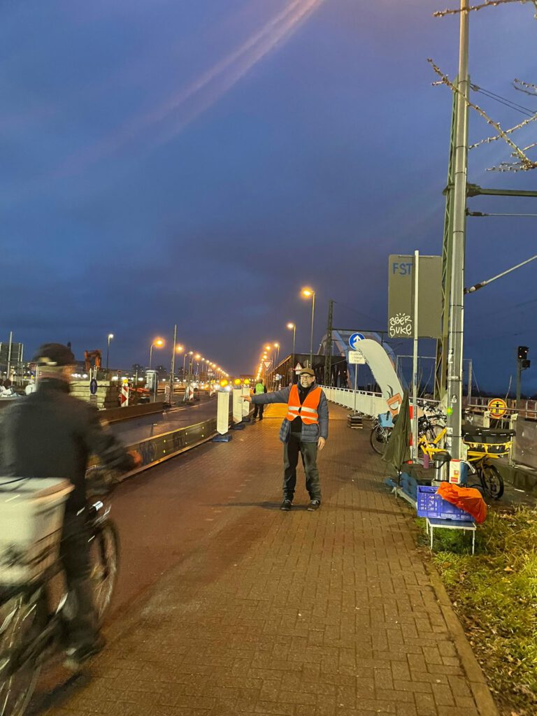 Wolfgang Mangold verteilt mit Freuden seine Muffins mit ausgestreckten Arm an einen Vorbeifahrenden, würde sich aber auch über Haltende freuen.